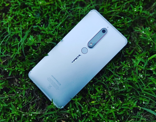 Ein Nokia-Handy liegt im Gras. Dabei ist die Rückseite mit dem Nokia Logo zu sehen.